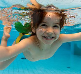 four year old boy swimming underwater at the Fredericksburg pool